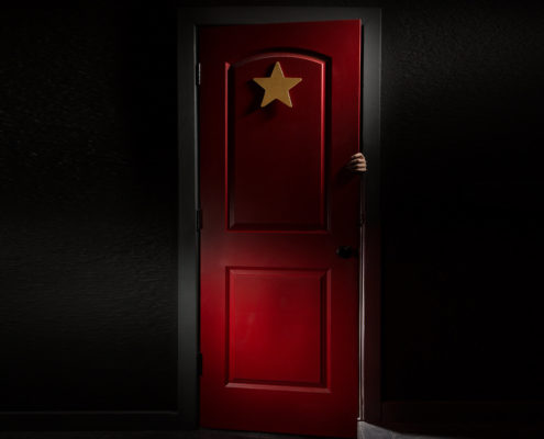 A photo of a mysterious red door with hand coming from within