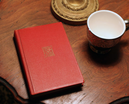 Photo of a red book and teacup on a table