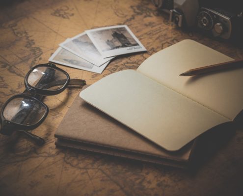 Photo of a notebook and glasses on a map