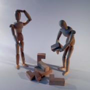 Photo of two figurines working on a block puzzle