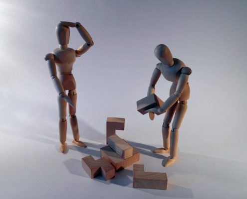 Photo of two figurines working on a block puzzle